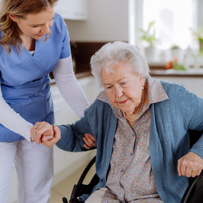 Persona mayor en una silla de ruedas estrecha para casa